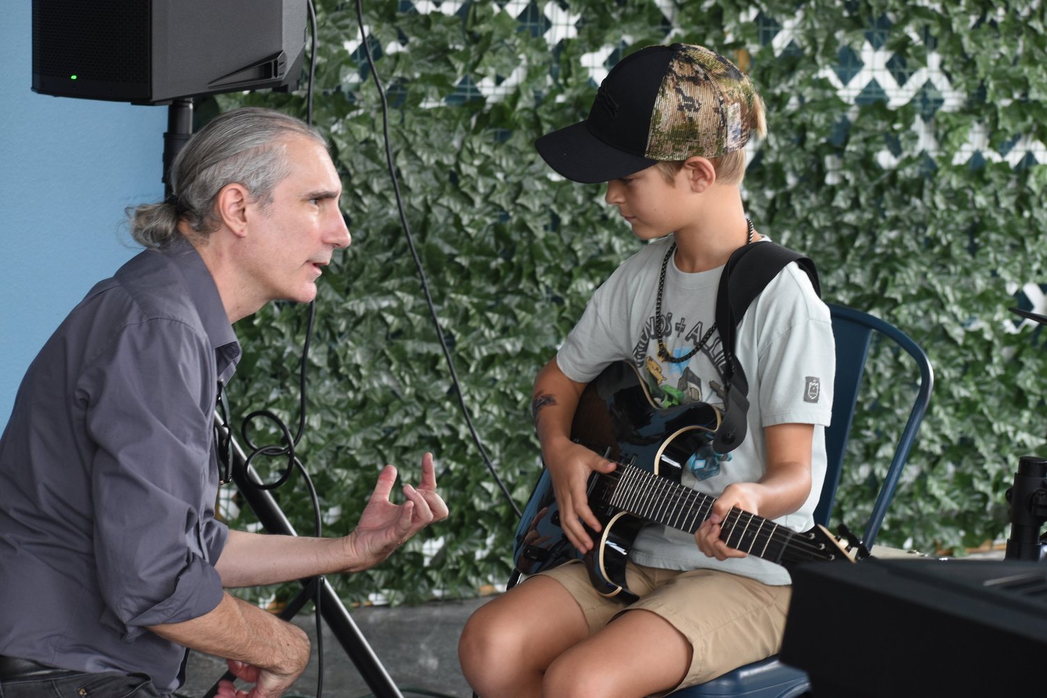 Guitar student playing alongside an instructor