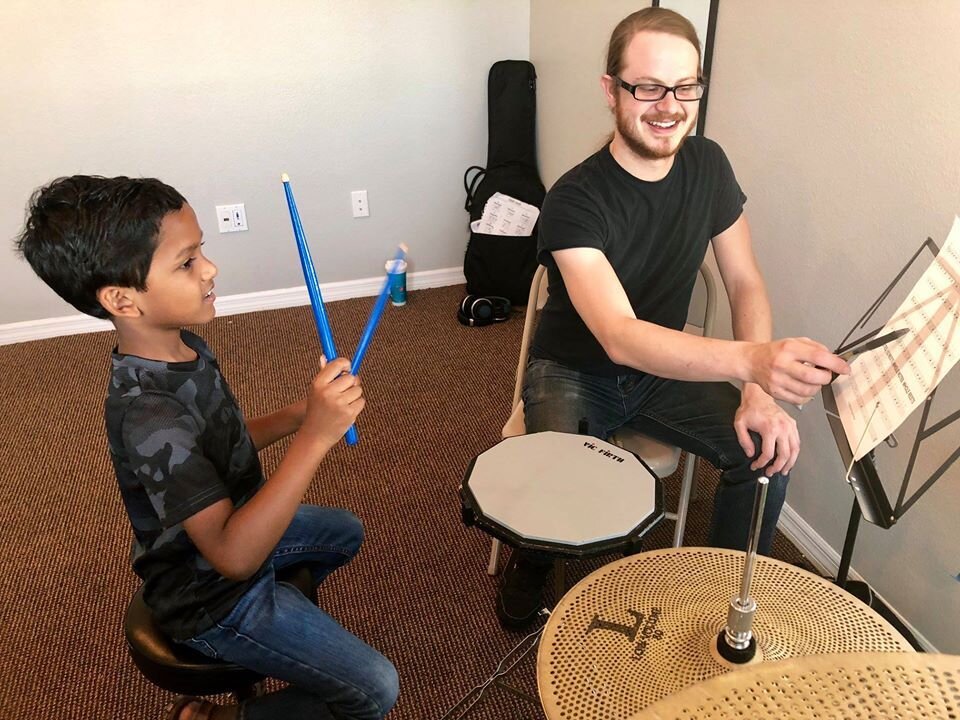 Teacher helping a student learn the drums